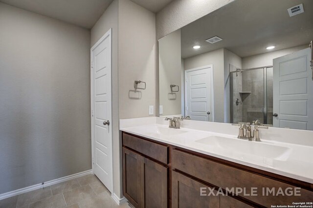7015 Comanche Cave, San Antonio, TX 78247 - bathroom with double vanity, visible vents, a shower stall, and a sink