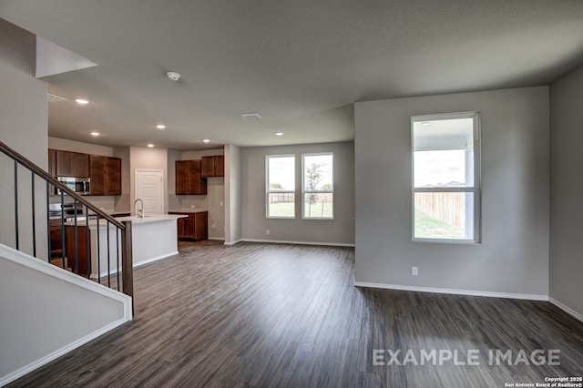 7015 Comanche Cave, San Antonio, TX 78247 - unfurnished living room featuring baseboards, dark wood-type flooring, and a healthy amount of sunlight