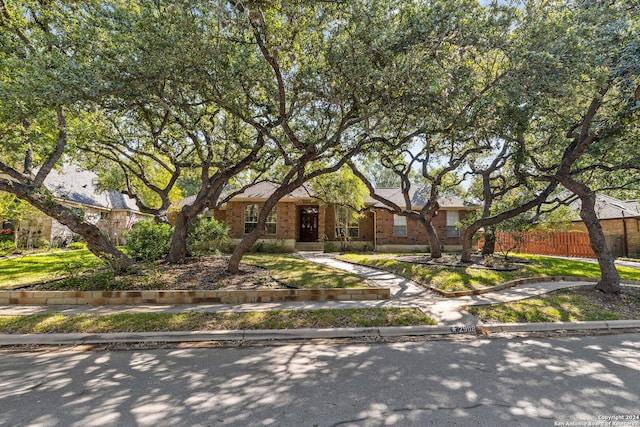 view of front of home featuring brick siding and fence