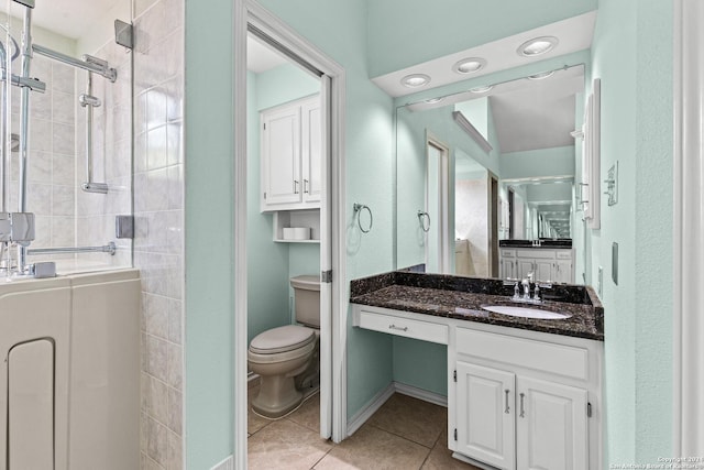 full bathroom featuring toilet, a stall shower, vanity, and tile patterned flooring