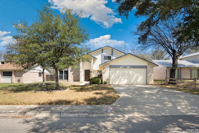 view of front facade with brick siding, driveway, a garage, and fence