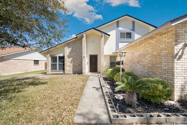 view of front of property featuring brick siding and a front yard