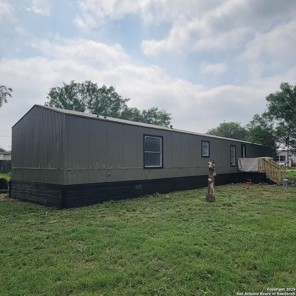 view of side of property featuring a lawn and crawl space