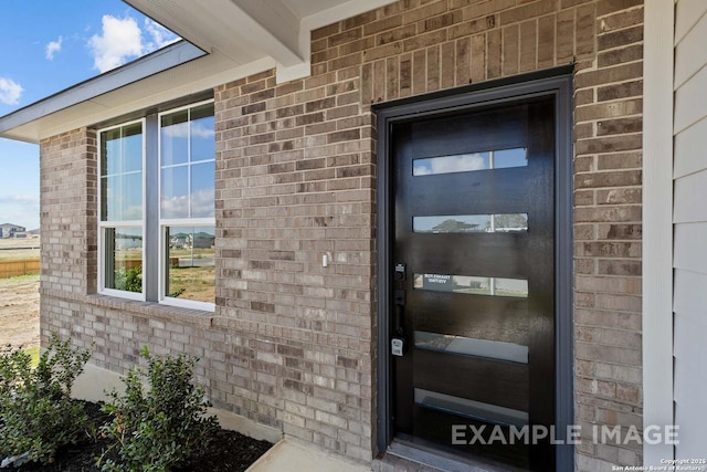 doorway to property featuring brick siding