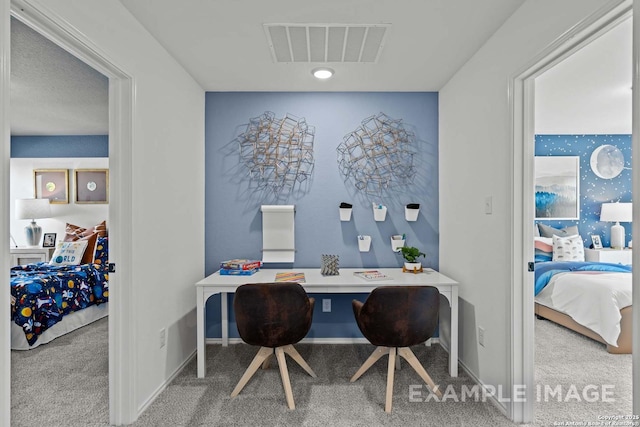 carpeted office featuring visible vents and baseboards