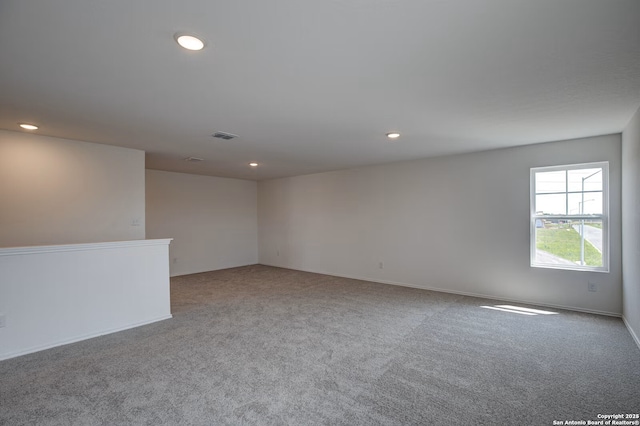 carpeted spare room featuring recessed lighting, visible vents, and baseboards