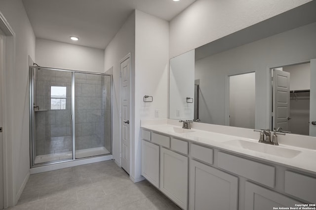 full bath featuring double vanity, a stall shower, and a sink