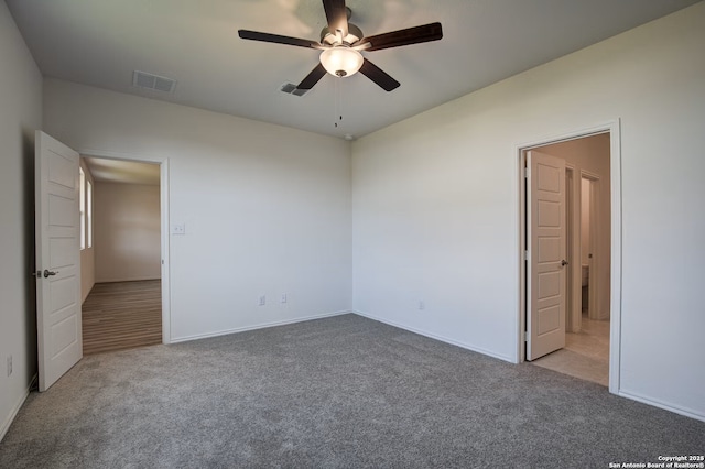 unfurnished bedroom featuring visible vents, carpet flooring, baseboards, and a ceiling fan