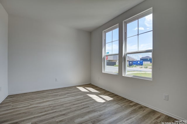 unfurnished room with baseboards and wood finished floors