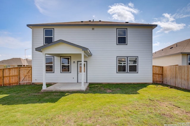 rear view of house with a patio area, a lawn, and a fenced backyard