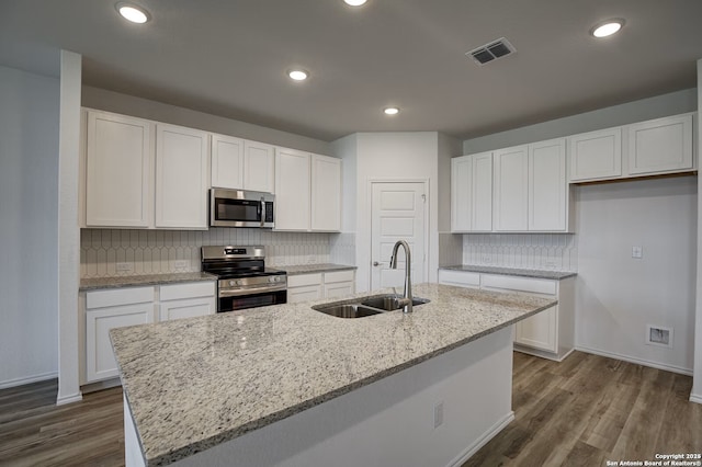 kitchen with a sink, visible vents, white cabinetry, and stainless steel appliances