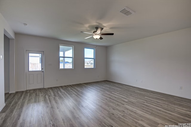 interior space featuring baseboards, wood finished floors, visible vents, and ceiling fan