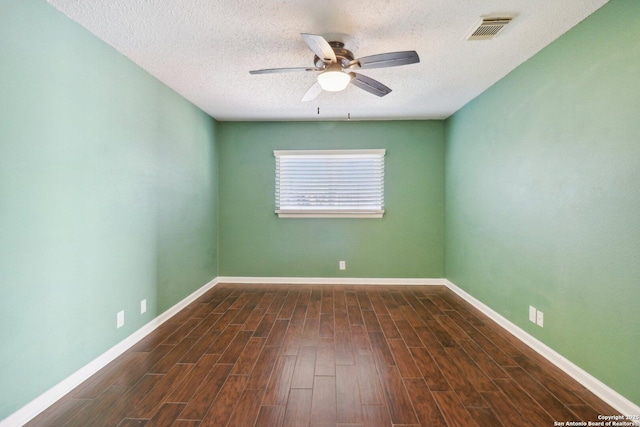 empty room featuring ceiling fan, visible vents, baseboards, and wood finished floors