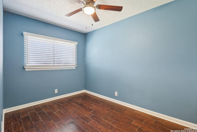 unfurnished room featuring dark wood finished floors, ceiling fan, baseboards, and a textured ceiling