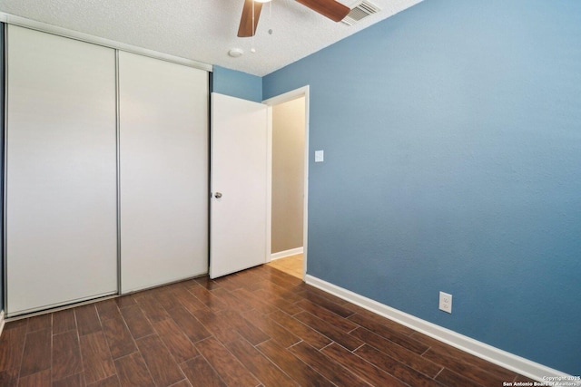 unfurnished bedroom with visible vents, wood finished floors, a closet, baseboards, and ceiling fan