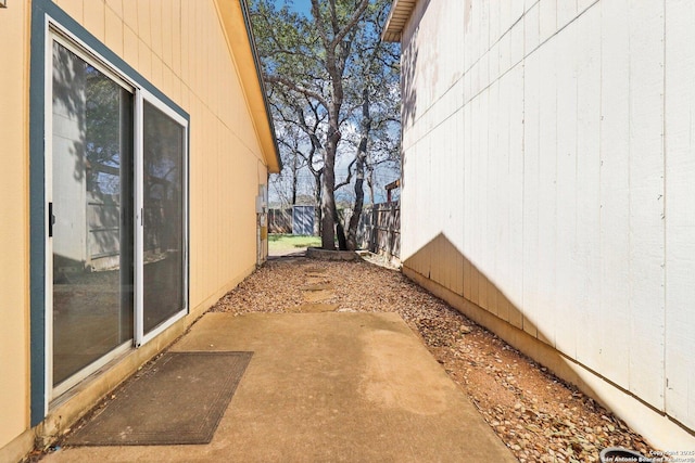 view of side of home featuring a patio and fence