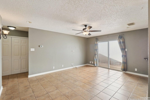 unfurnished room with light tile patterned flooring, visible vents, baseboards, and ceiling fan