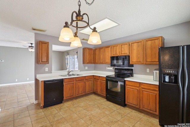 kitchen featuring visible vents, black appliances, a sink, brown cabinetry, and light countertops