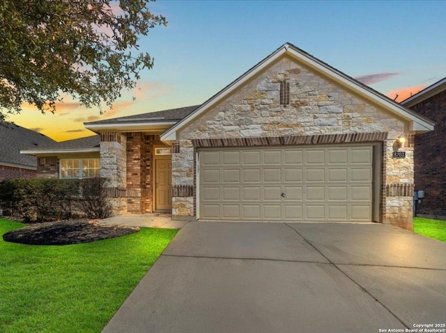 view of front of house featuring stone siding, a front yard, concrete driveway, and an attached garage