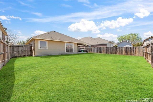 rear view of property featuring a fenced backyard and a yard