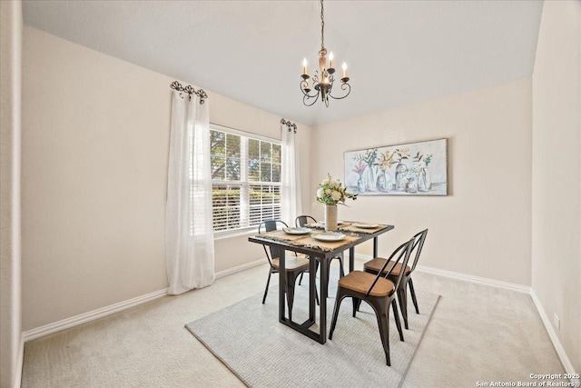 dining room with baseboards, light carpet, and a chandelier