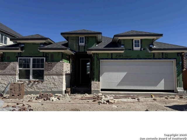 view of front of house featuring brick siding and a garage