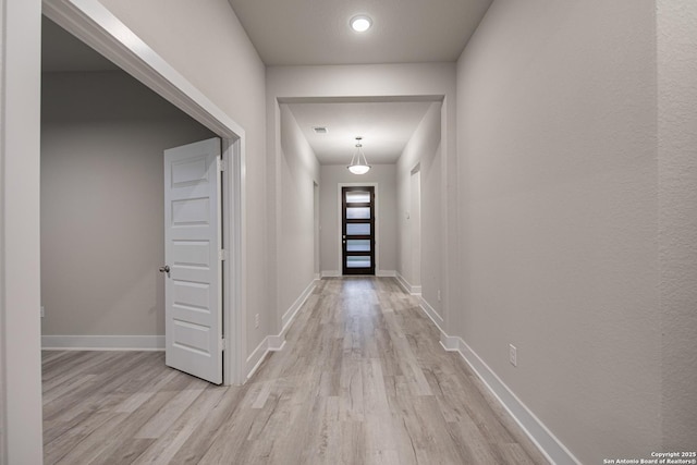 corridor with visible vents, baseboards, and wood finished floors