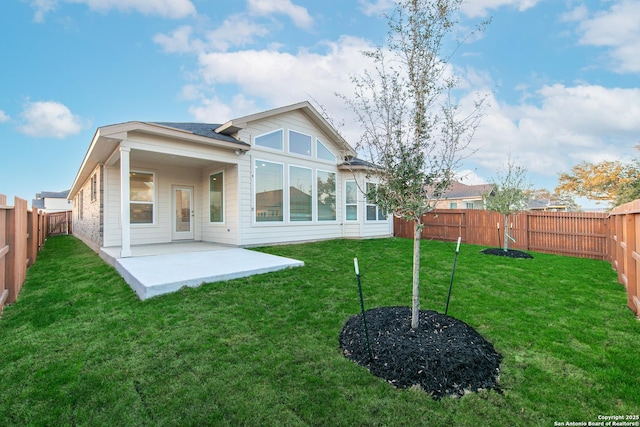 back of property featuring a patio, a lawn, a fenced backyard, and brick siding