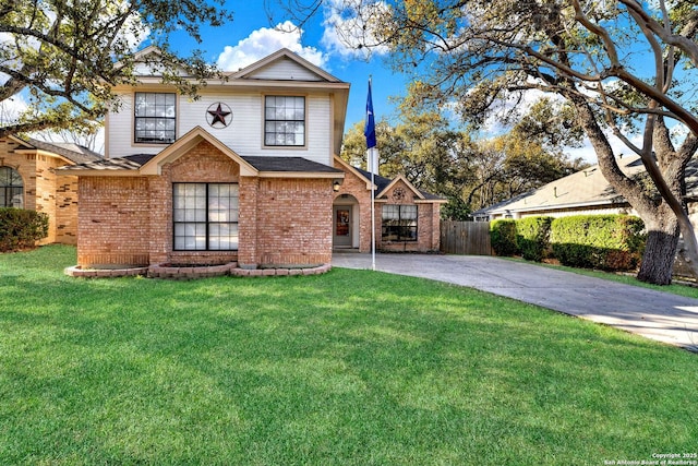 traditional home featuring a front lawn, concrete driveway, fence, and brick siding