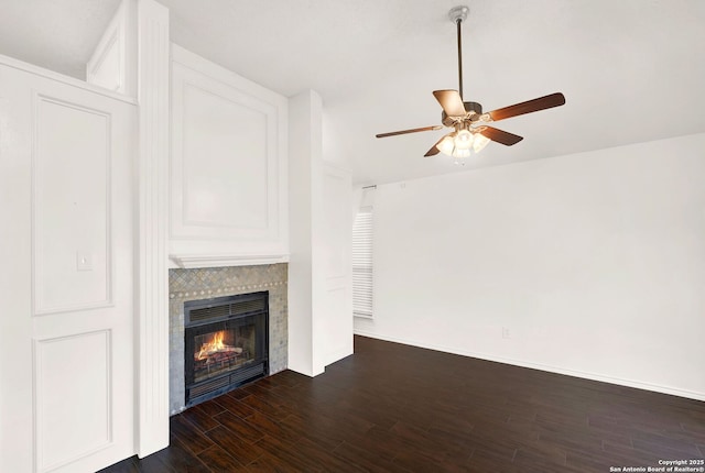 unfurnished living room featuring ceiling fan, baseboards, dark wood-style floors, and a fireplace