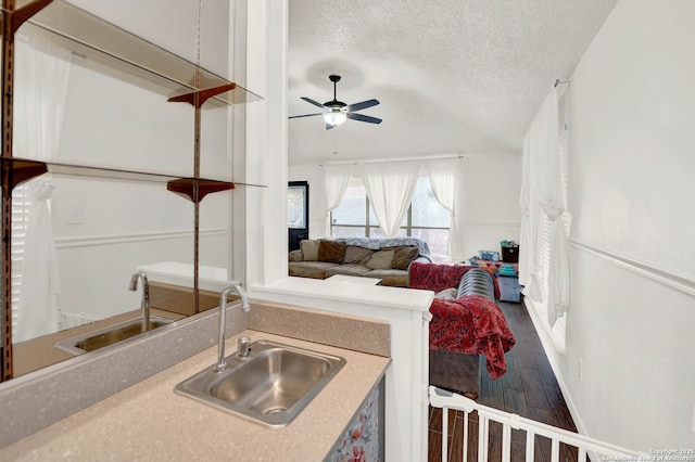 kitchen featuring a sink, a textured ceiling, wood finished floors, and ceiling fan