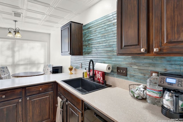 kitchen with dark brown cabinetry, an ornate ceiling, and a sink