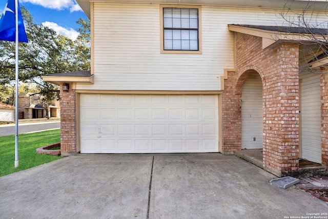 view of front of home with driveway, brick siding, and an attached garage