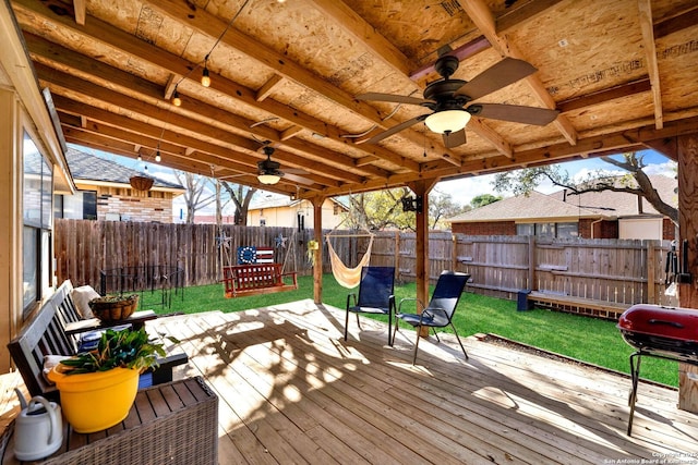 deck featuring a yard, area for grilling, a fenced backyard, and a ceiling fan