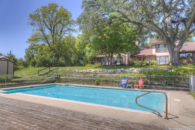 view of pool featuring a fenced in pool, an outbuilding, and fence