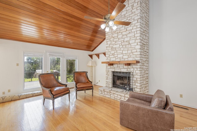 living room featuring a fireplace, high vaulted ceiling, light wood-type flooring, wooden ceiling, and a ceiling fan