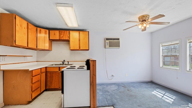 kitchen with brown cabinets, white range with electric cooktop, a wall unit AC, light countertops, and baseboards