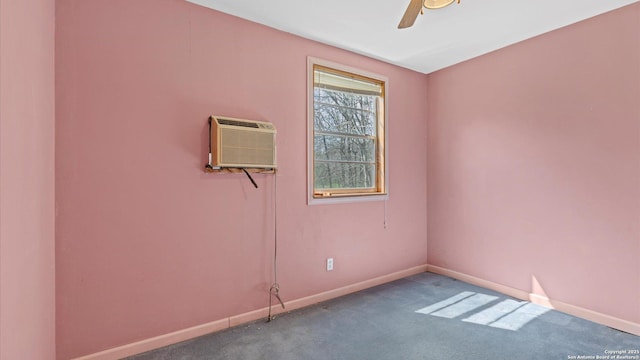 carpeted empty room with an AC wall unit, baseboards, and a ceiling fan