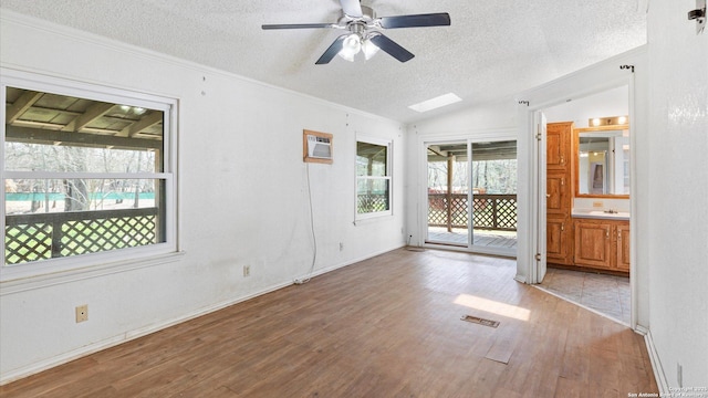 unfurnished room featuring visible vents, a textured ceiling, wood finished floors, lofted ceiling, and ceiling fan