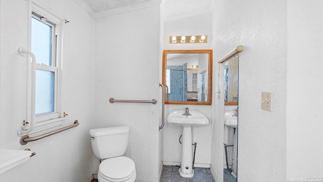 bathroom featuring a wealth of natural light, toilet, and crown molding