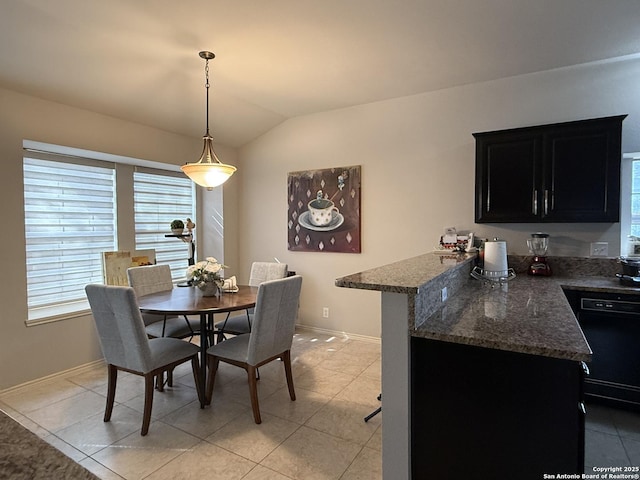 dining room featuring light tile patterned floors, baseboards, and lofted ceiling