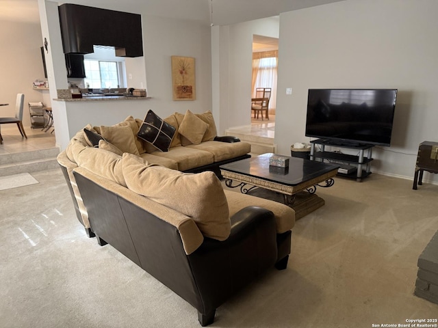 living room featuring light colored carpet and baseboards