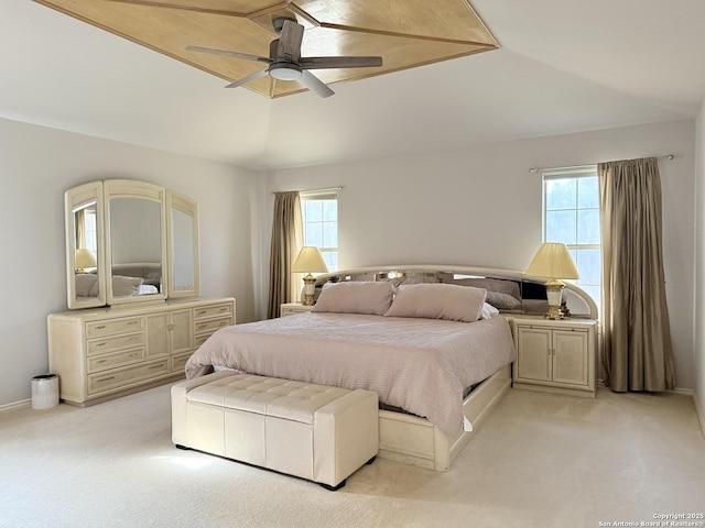 bedroom with ceiling fan, vaulted ceiling, multiple windows, and light carpet