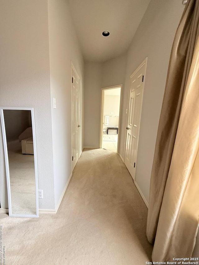 corridor with baseboards and carpet