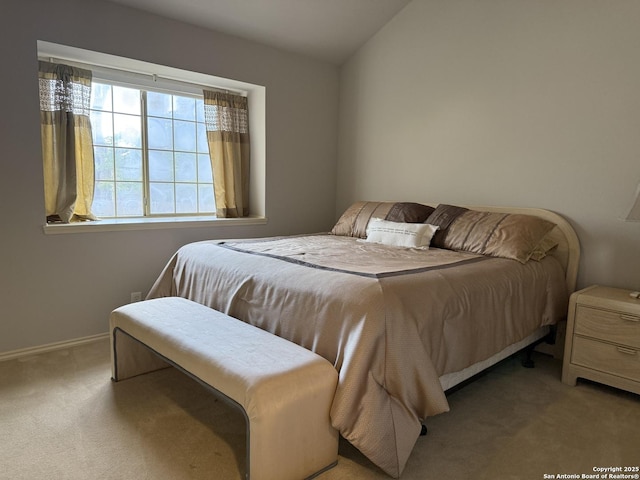 bedroom with baseboards, lofted ceiling, and carpet