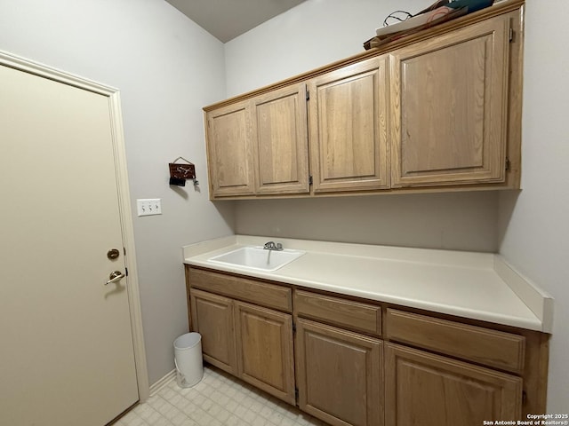 laundry area featuring light floors and a sink