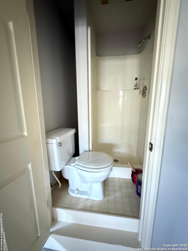 bathroom featuring toilet and a stall shower