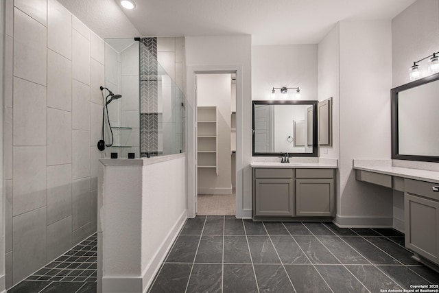 full bathroom featuring vanity, baseboards, and walk in shower