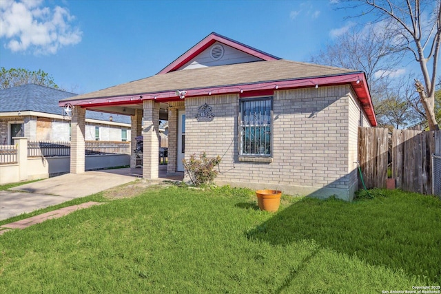 view of front of property with a front yard, fence, and brick siding