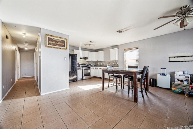 dining room featuring light tile patterned floors, baseboards, visible vents, and ceiling fan